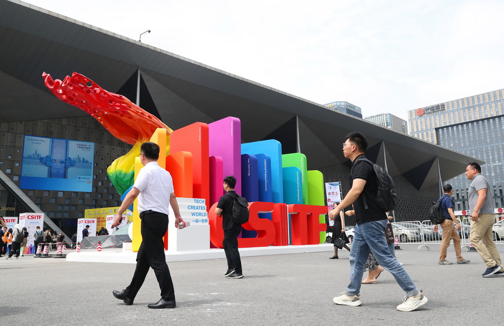 6月12日，参观者从第十届中国（上海）国际技术进出口交易会迎宾展板前走过。