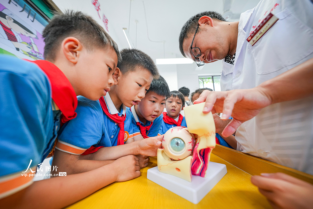 2025年6月5日,江西省抚州市南丰县登高小学,医生在向学生讲解眼睛的构造。谢东摄(人民图片网)