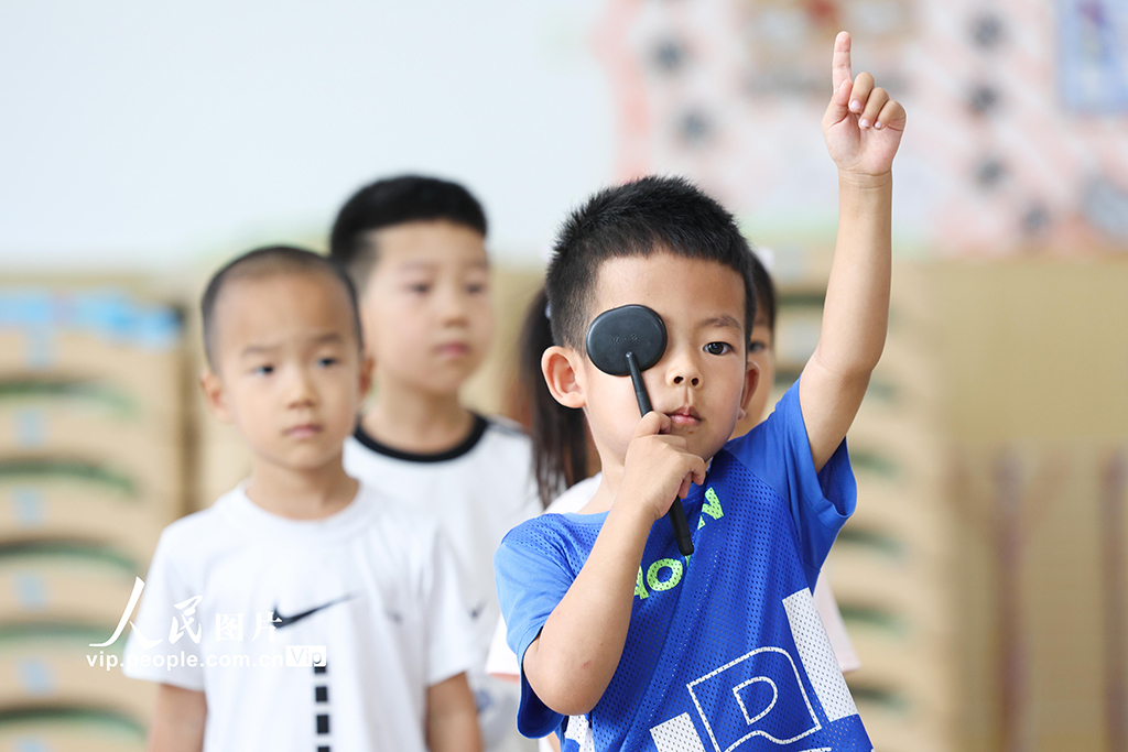 2025年6月5日,河北省石家庄市华北幼儿园的小朋友在老师组织下,有序接受视力筛查。梁子栋摄(人民图片网)